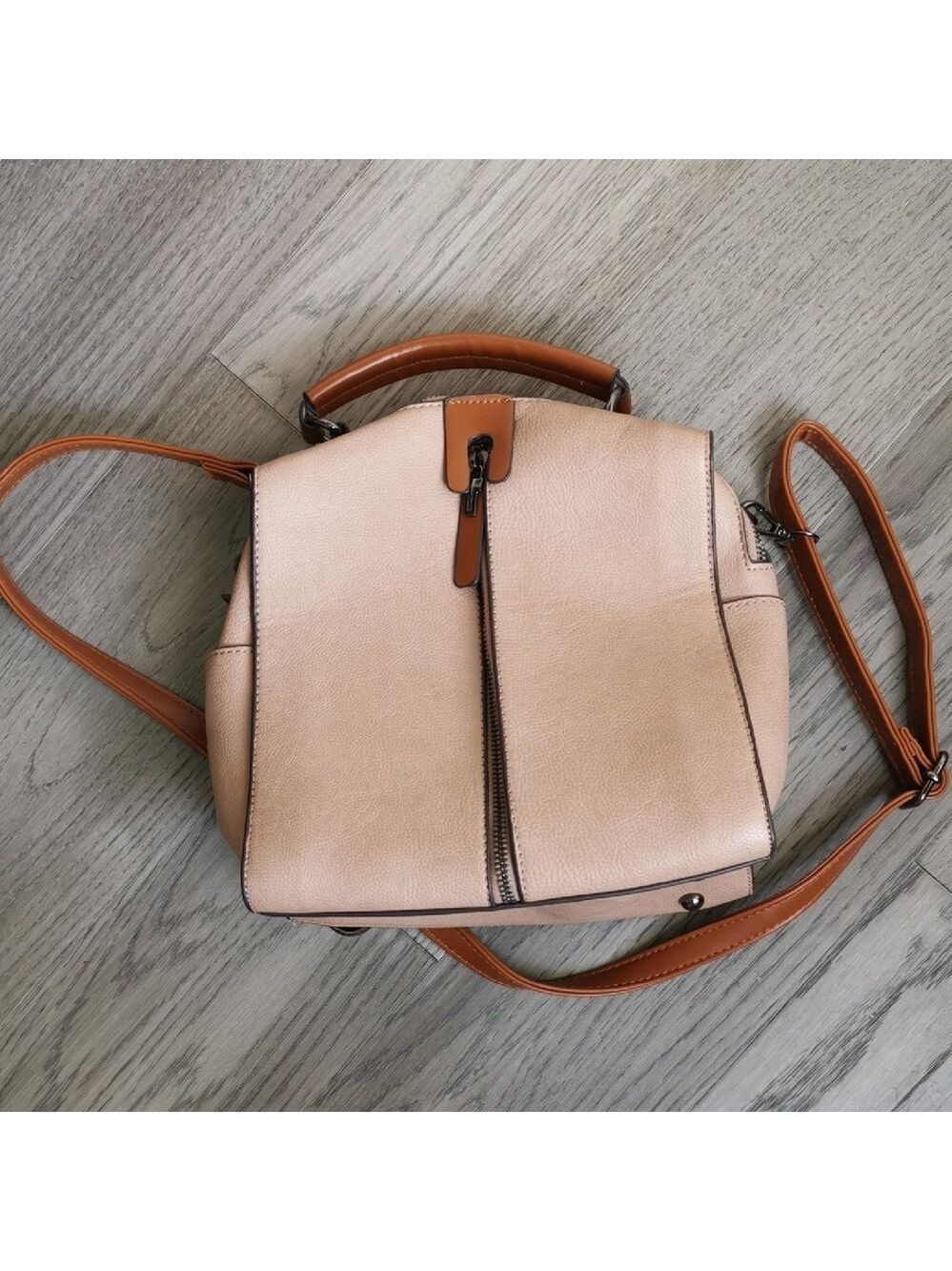 Pinkinsh- brown leather like womens satchel with brown handles. Lots of zippers